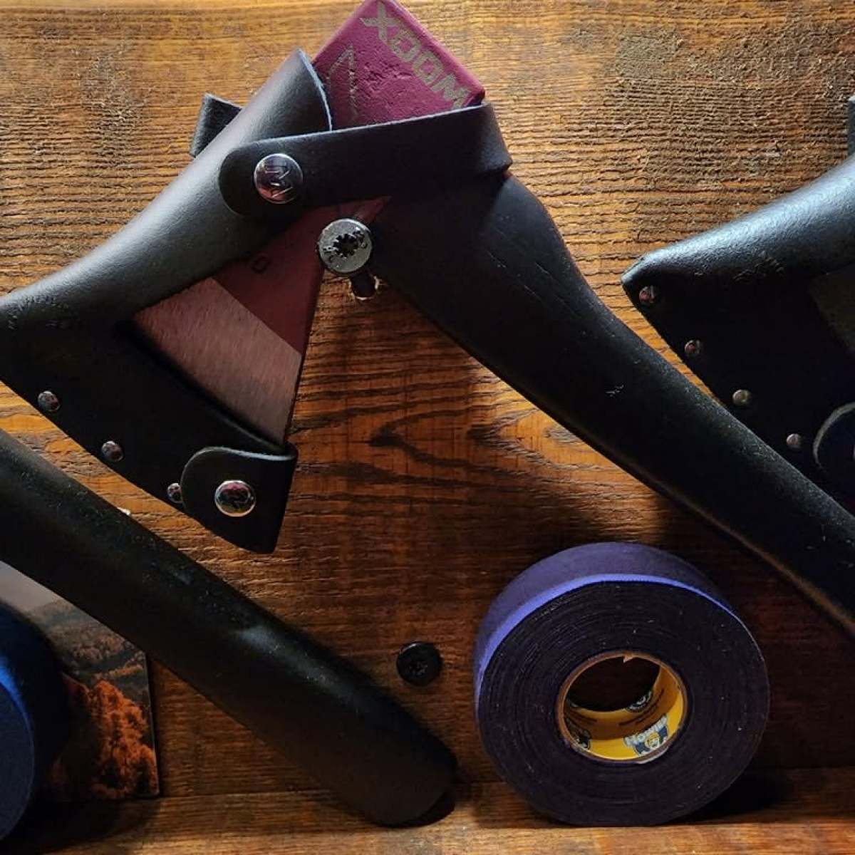 Ice skates with purple tape on wooden surface