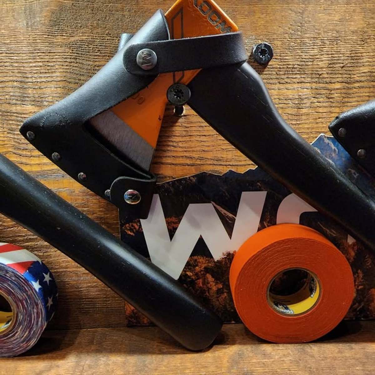 Tools on a wooden surface with tape and a magazine.