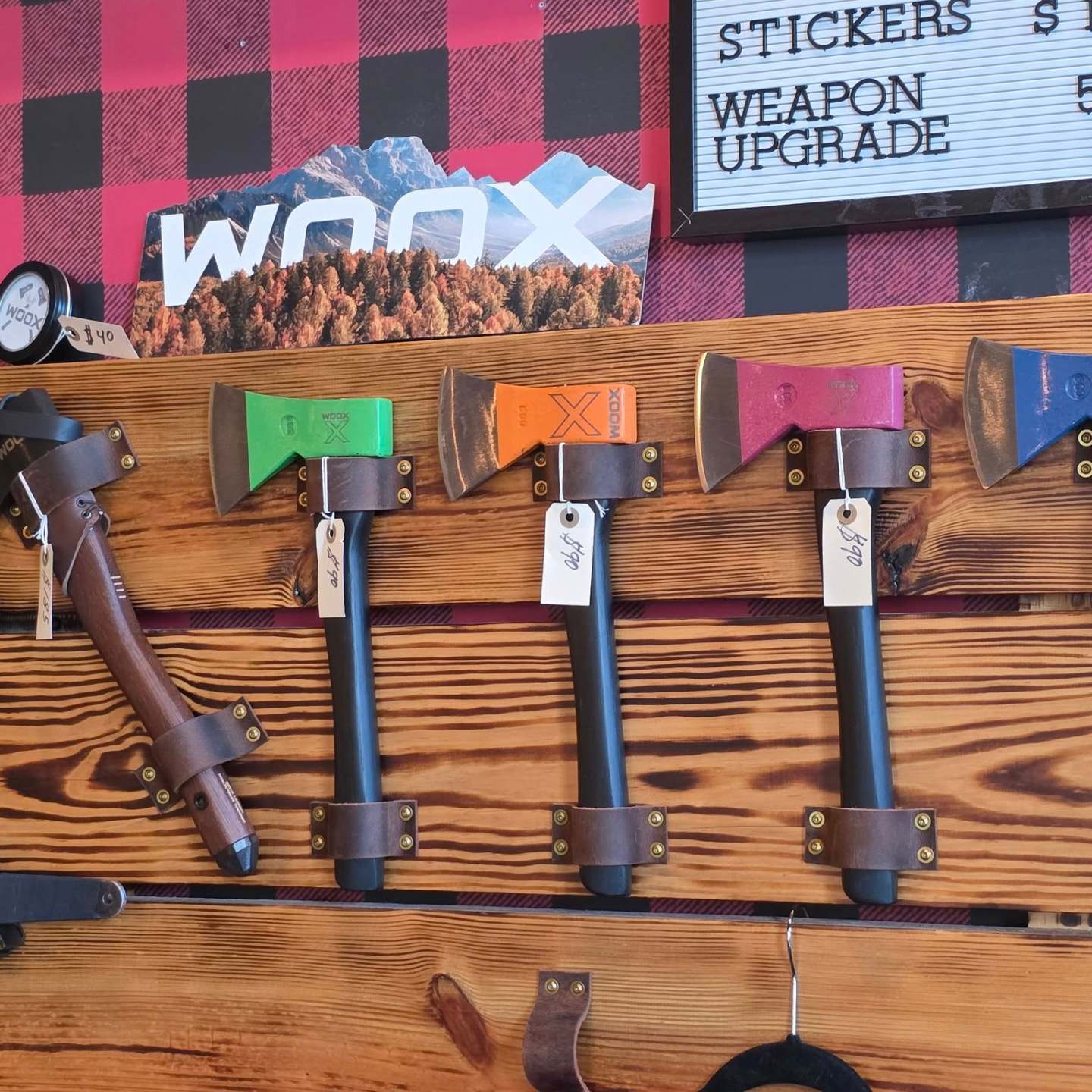Colorful axes displayed on a wooden board with price signs.