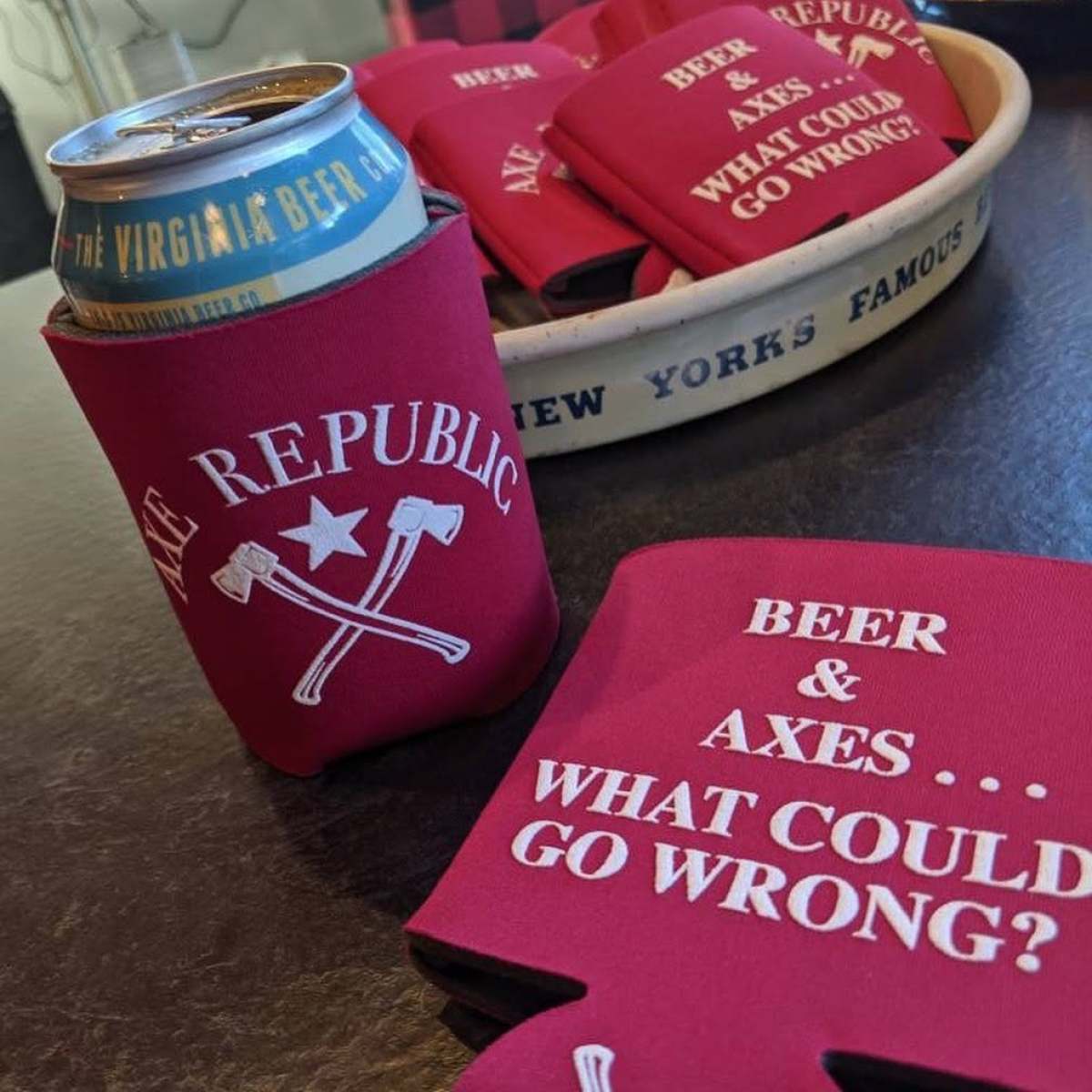 Can in holder with crossed axes and text: 'Beer & Axes... What could go wrong?'. Tray with similar sleeves.