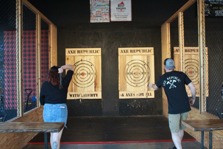 Two people axe throwing in lanes marked 'Axe Republic'.